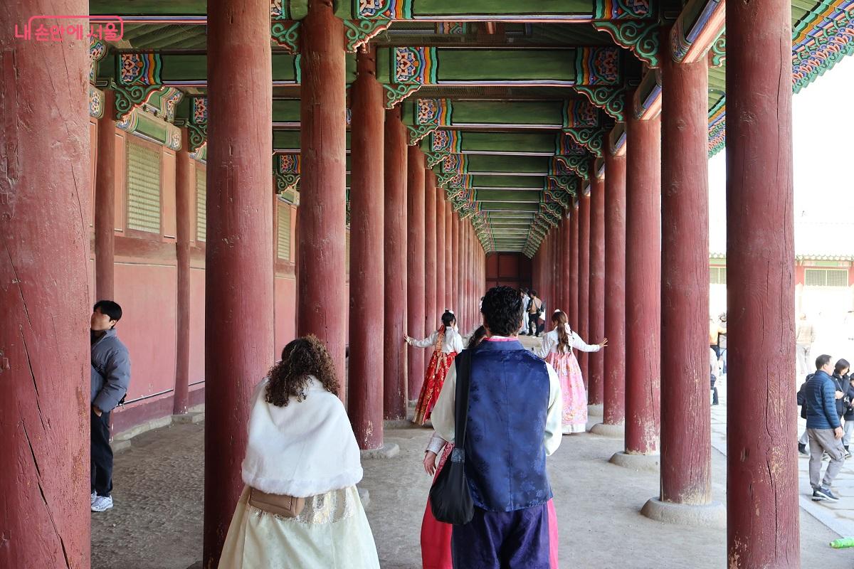 질서정연하게 늘어선 붉은 기둥 사이 회랑을 거닐며 궁궐 건축의 수직적 미학을 만끽하는 방문객들 &copy;김대진