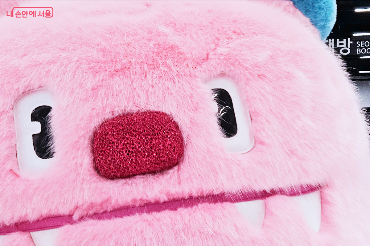 해치 인형 탈 사진. 사진에 해치 얼굴이 가득 차 있다.