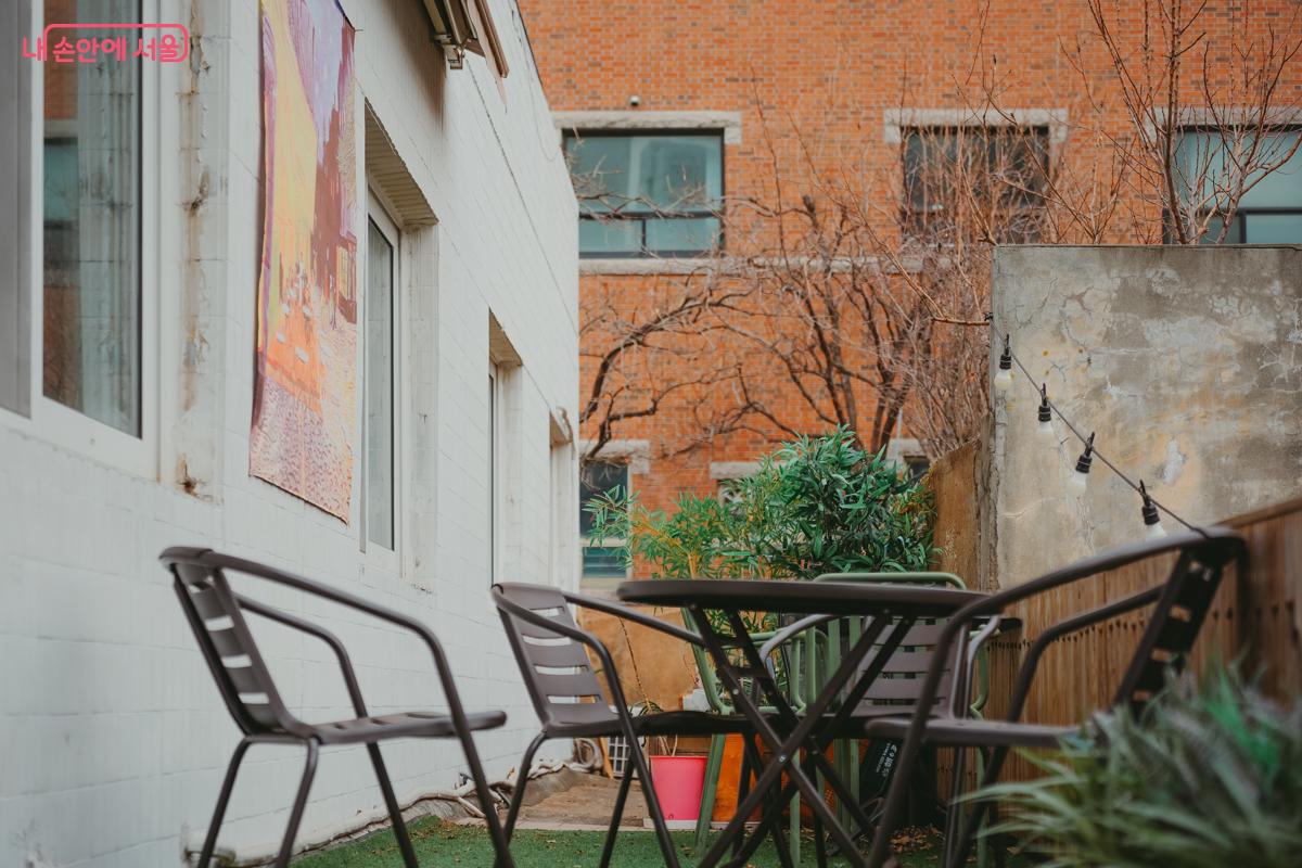 인조 잔디가 깔린 야외 공간에 철제 테이블과 의자가 놓여 있다. &copy;김성무