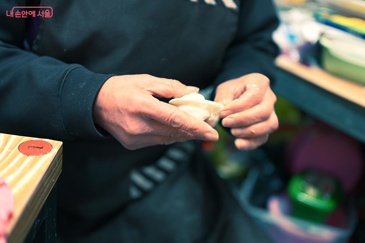 가게에서 수제 만두를 빚고 있는 상인 &copy;한솔