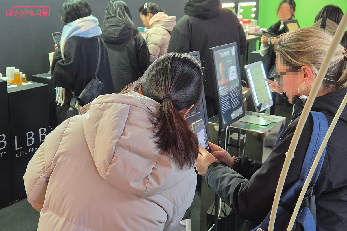 비더비(B the B)가 제공하는 맞춤형 AI 뷰티 서비스를 체험하고 있는 외국인 관광객 &copy;백승훈