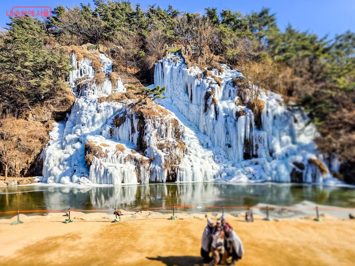 얼어 붙은 홍제천 폭포 빙벽을 배경으로 외국인 관광객이 사진을 찍고 있다. ⓒ양지영