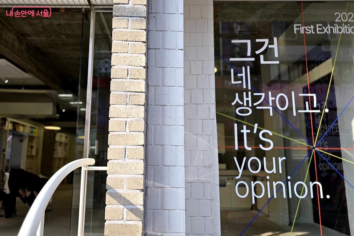 입구 창에 첫 전시 제목 '그건 네 생각이고'가 붙어 있다. &copy;김윤경