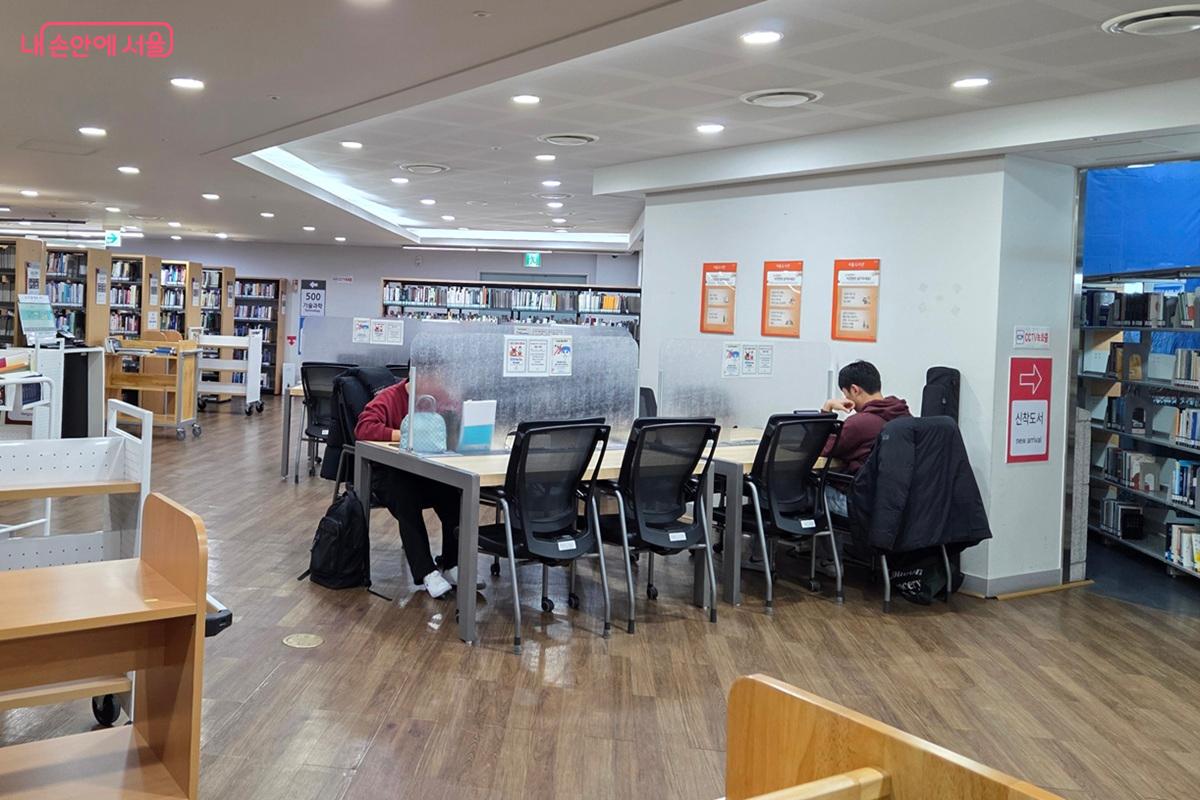 따듯한 실내의 높은 천장, 밝은 조명 아래서 독서에 빠진 시민들 ©이상돈