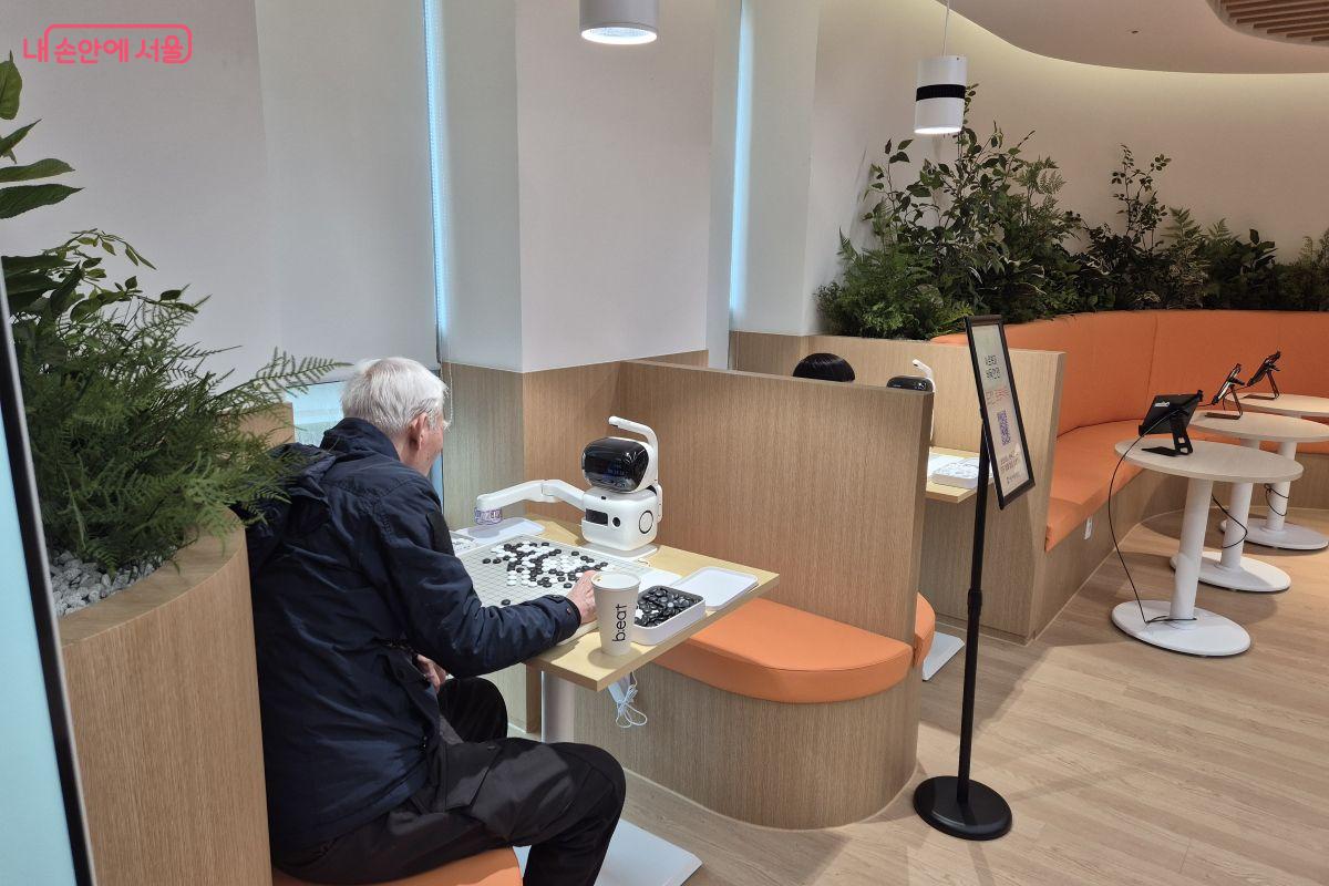 로봇과 진지하게 바둑을 두고 있는 시니어 &copy;조현정