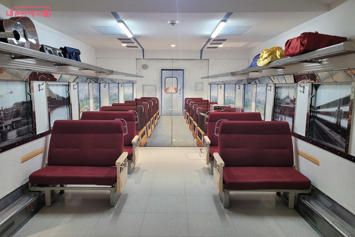 객차 내부를 재현한 전시 공간. 붉은 좌석과 수하물 선반이 인상적이다. &copy;조연