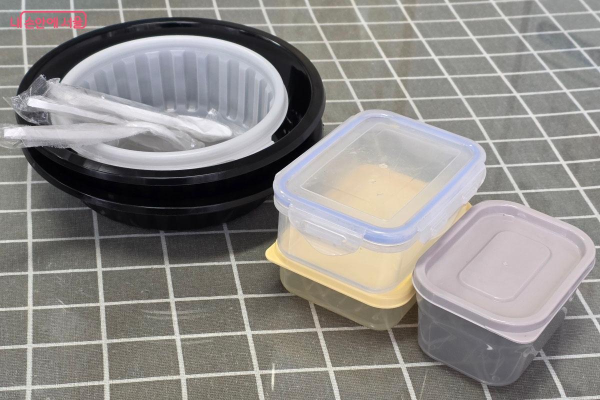 깨끗하게 세척된 배달용 플라스틱 용기들이 건조대 위에 놓여 있습니다. 재활용을 위해 이물질 없이 씻어낸 모습입니다.