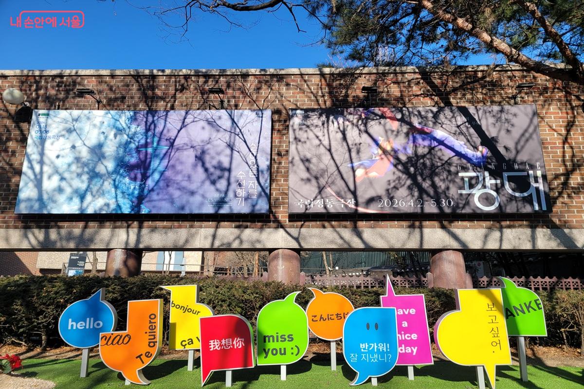정동 거리의 벽면에 공연 배너가 걸려 있고, &lsquo;hello&rsquo;, &lsquo;ciao&rsquo;, &lsquo;bonjour&rsquo; 등 다국어 인사말 조형물이 설치된 모습.