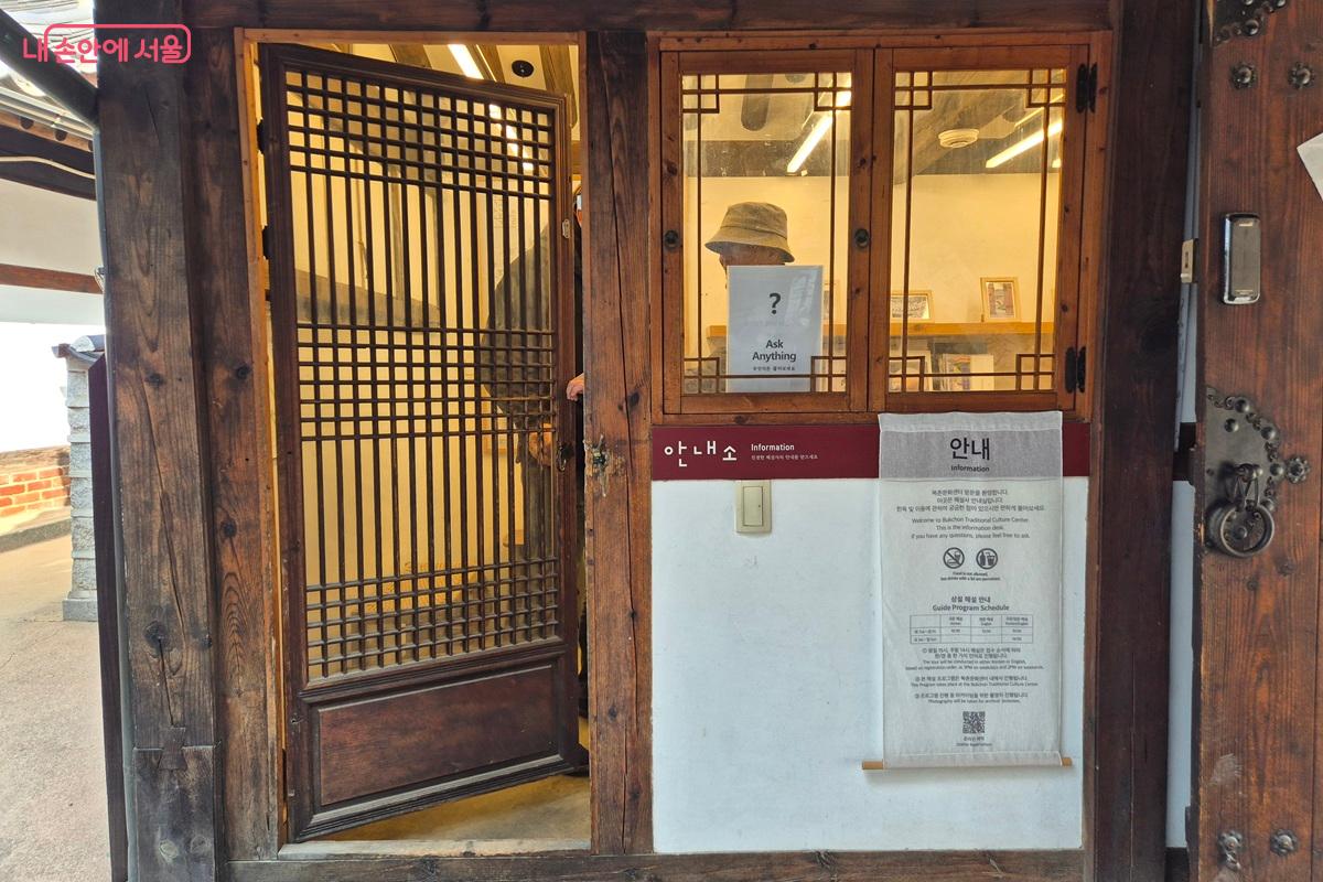 북촌문화센터 입구에 위치한 안내소에는 상주 해설사가 있다. 관광객 한 명이 안내소를 방문해 상주 해설사에게 질문을 하며 궁금증을 해결하고 있다. &copy;마가은