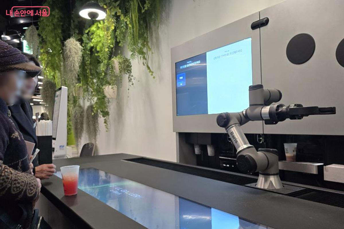 로봇이 건넨 음료를 받아 든 채 한동안 그 자리를 떠나지 못하는 시민들 &copy;김경희