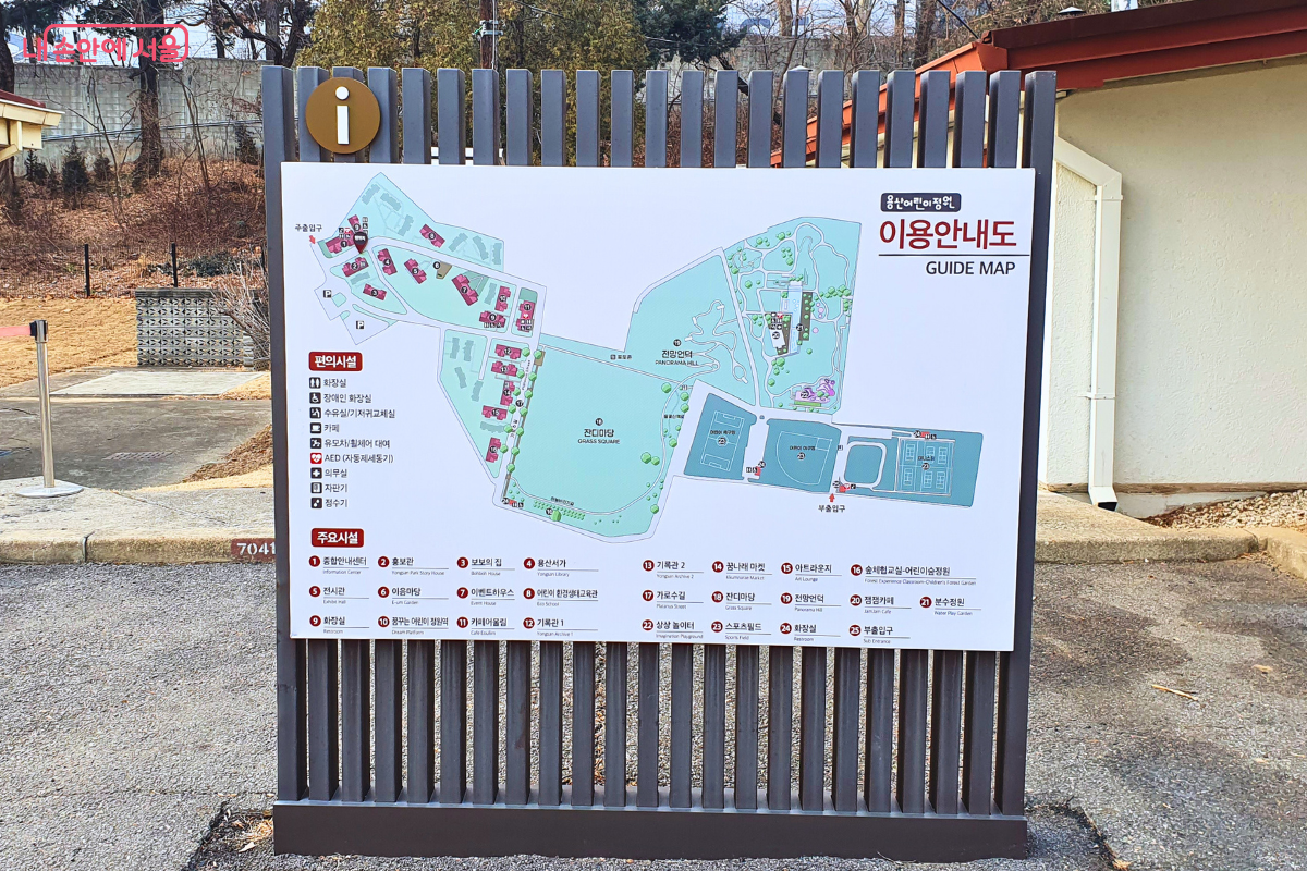 용산어린이정원의 전체 지도가 그려진 대형 이용안내도이다. 잔디마당, 전망언덕, 카페어울림, 용산서가 등 주요 시설의 위치가 상세히 표시되어 있다.