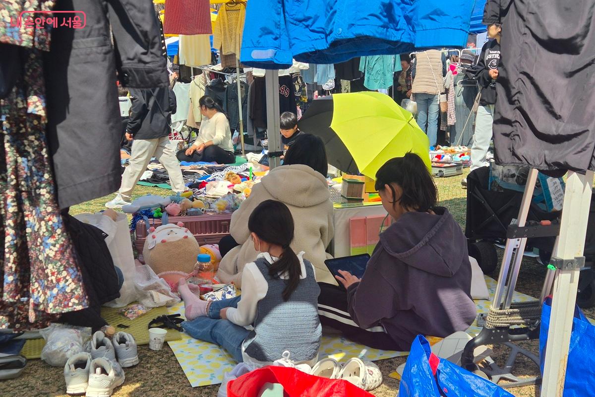가족 단위로 판매에 참여하는 시민들이 앉아 있다. '은평구민 나눔장터'는 아이들에게 간접적인 경제활동의 기회를, 어른들에게는 사용하지 않는 물건을 나누는 기회를 제공한다. ©마가은