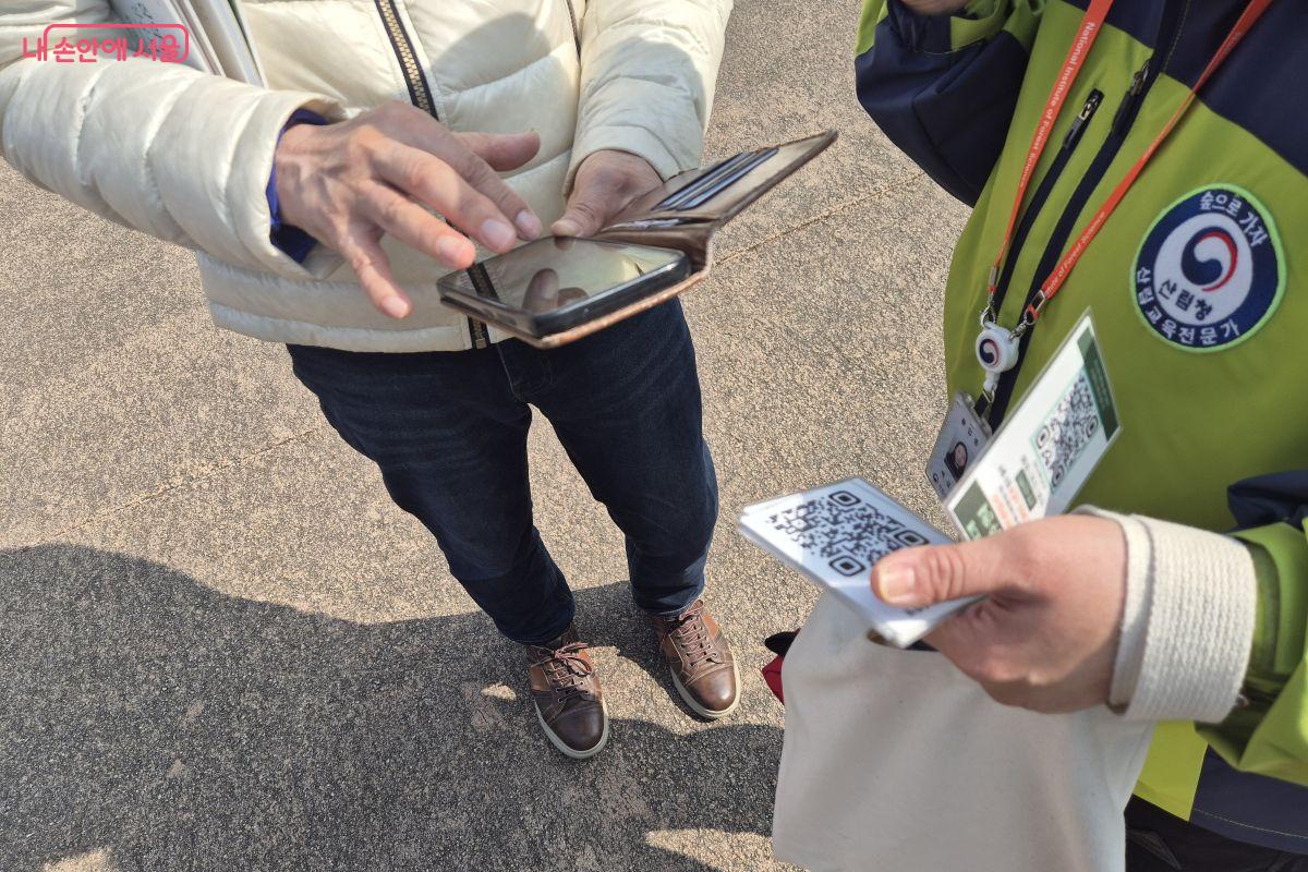 QR코드로 예약 방법을 안내하고 있는 숲해설가 &copy;조현정