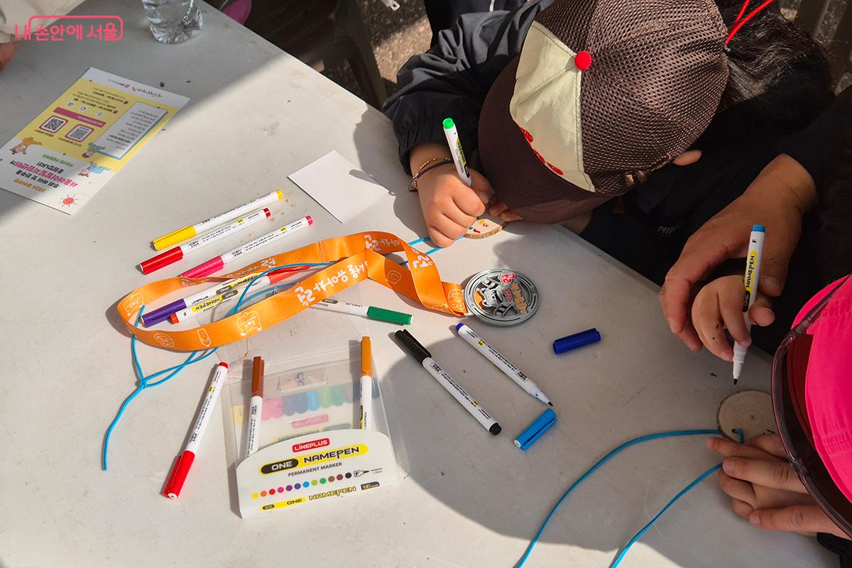 완주 메달에 자신만의 메세지를 새겨넣는 어린이 참가자의 모습