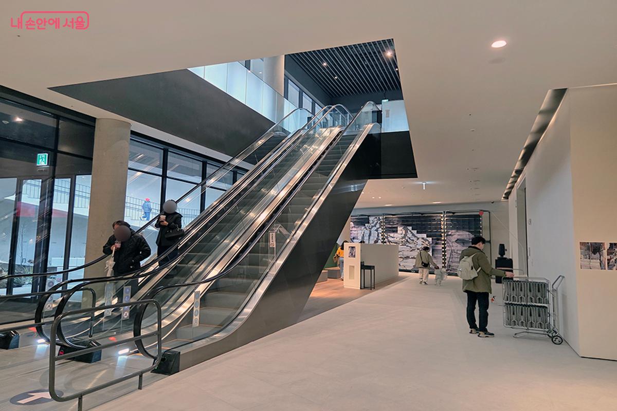 에스컬레이터를 이용해 각 층의 전시 공간을 자유롭게 이동하는 시민들 ⓒ이다현