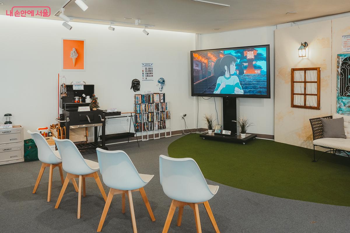 인조 잔디 위에 의자가 놓여있고 대형 모니터가 설치된 다락 아트 시네마 전경 &copy;김성무