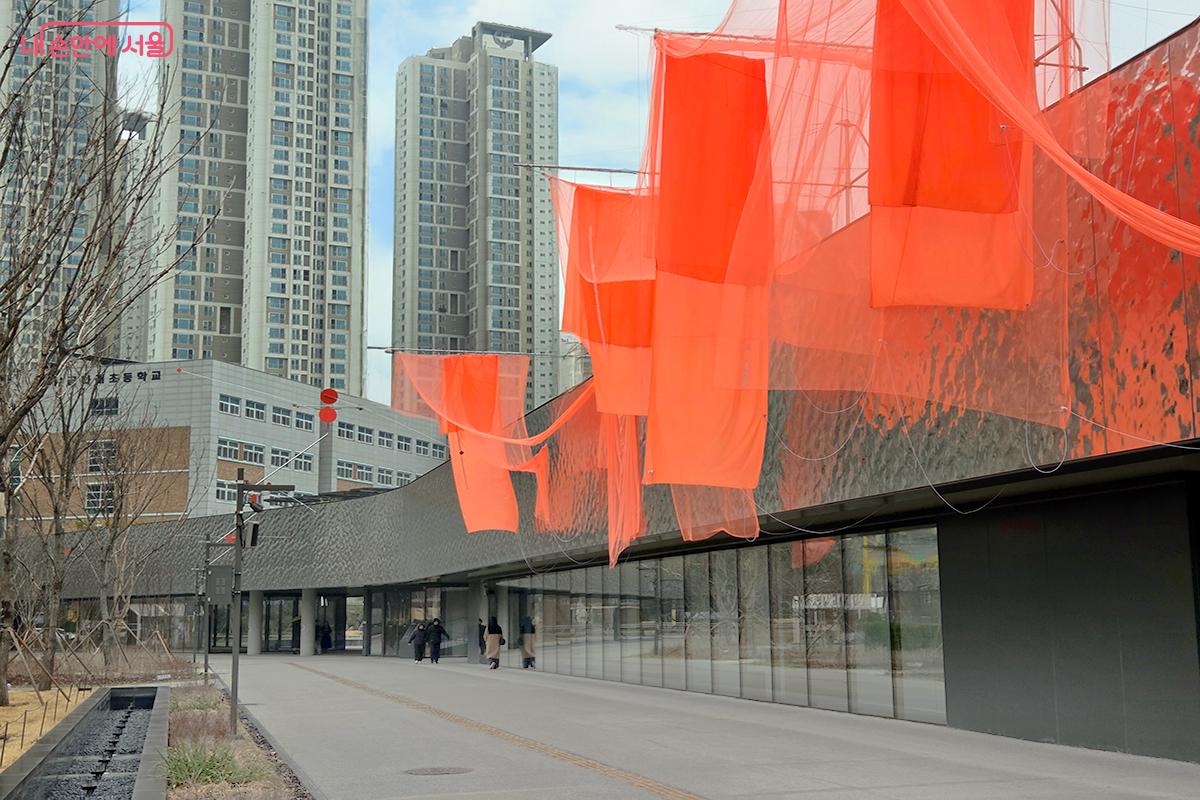 미술관 전경을 화려하게 채우며 관람객의 눈길을 사로잡는 붉은 계열의 천 조형물 ⓒ이다현
