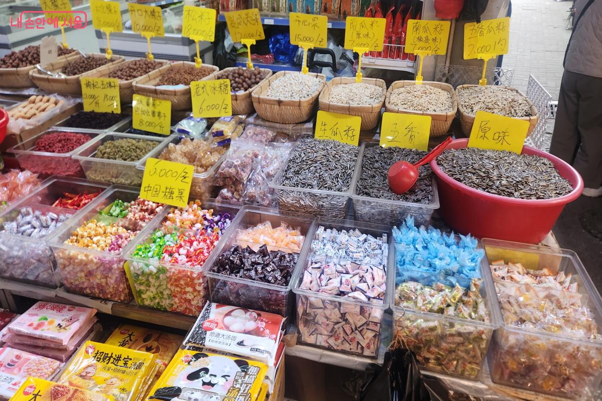 남구로시장 한 점포에 해바라기씨와 사탕 등 다양한 간식류가 진열돼 있다. 판매대 뒤 노란색 바탕의 가격표에는 한자와 숫자로 가격이 표기돼 있다.