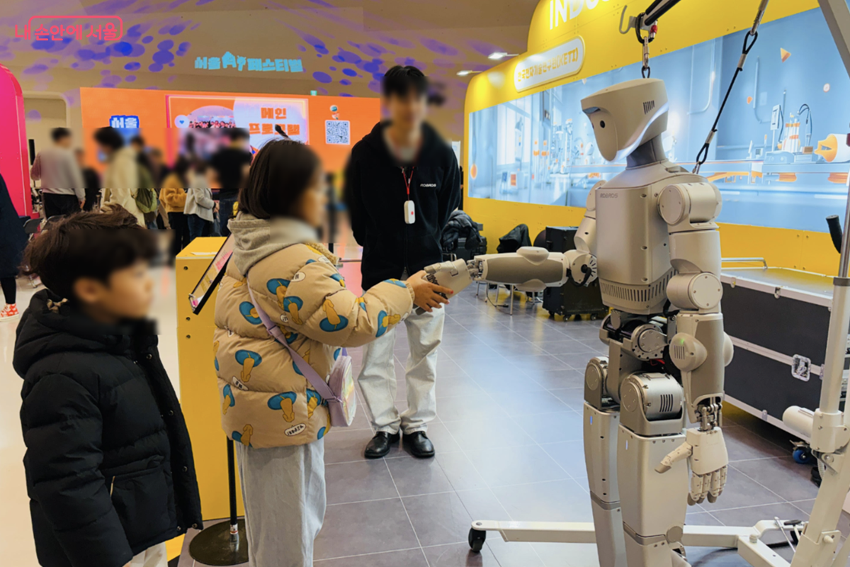 로봇과 악수하기 위해서 줄을 서있는 어린이들 &copy; 김경선