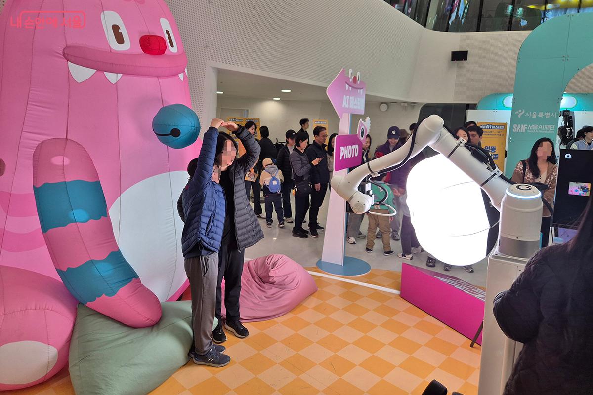 ‘AI기술체험존’ 포토존에서 AI 로봇팔이 찍어주는 사진으로 소중한 추억을 남길 수 있다.