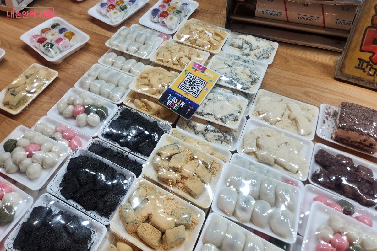 남구로시장 한 떡가게에 인절미, 꿀떡, 쑥떡 등 다양한 떡이 포장돼 진열돼 있다. 판매대 중앙에는 서울페이 결제를 위한 QR코드 안내판이 놓여 있다.