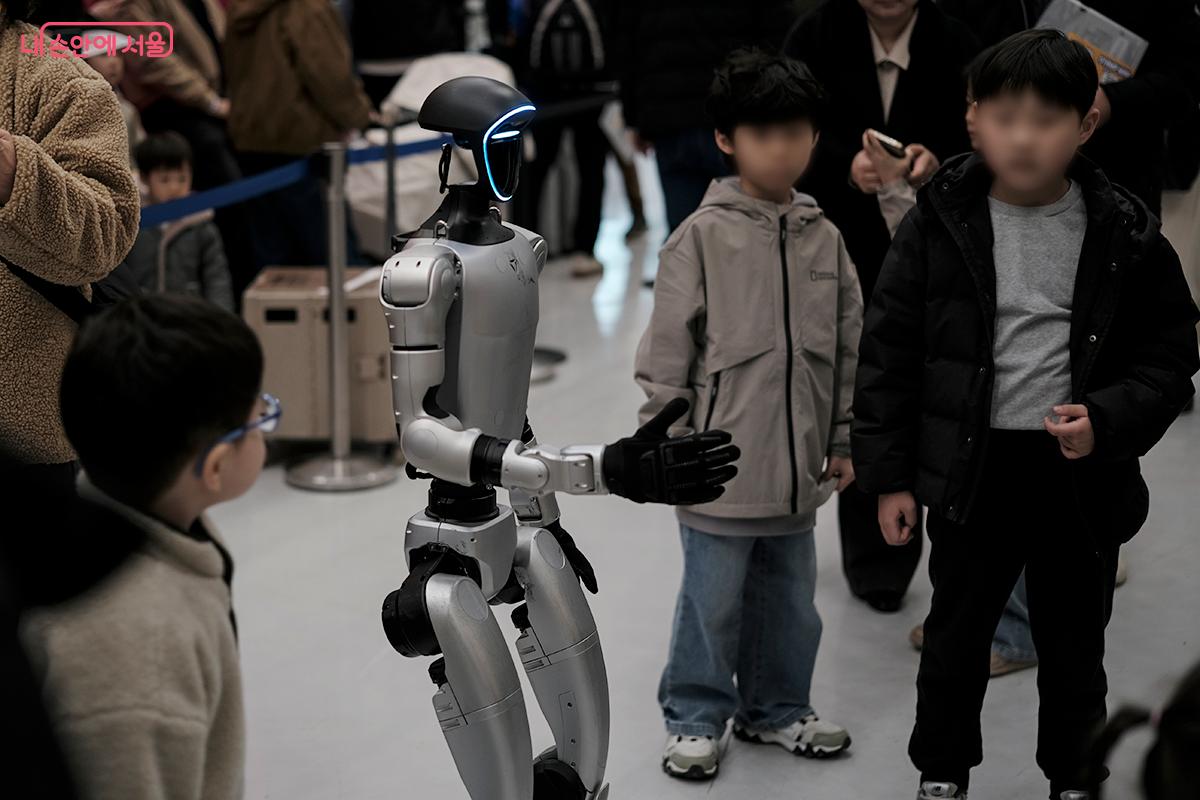 아이들이 자기 키 만한 휴머노이드 로봇을 관심있게 살펴보고 있다. ⓒ김아름