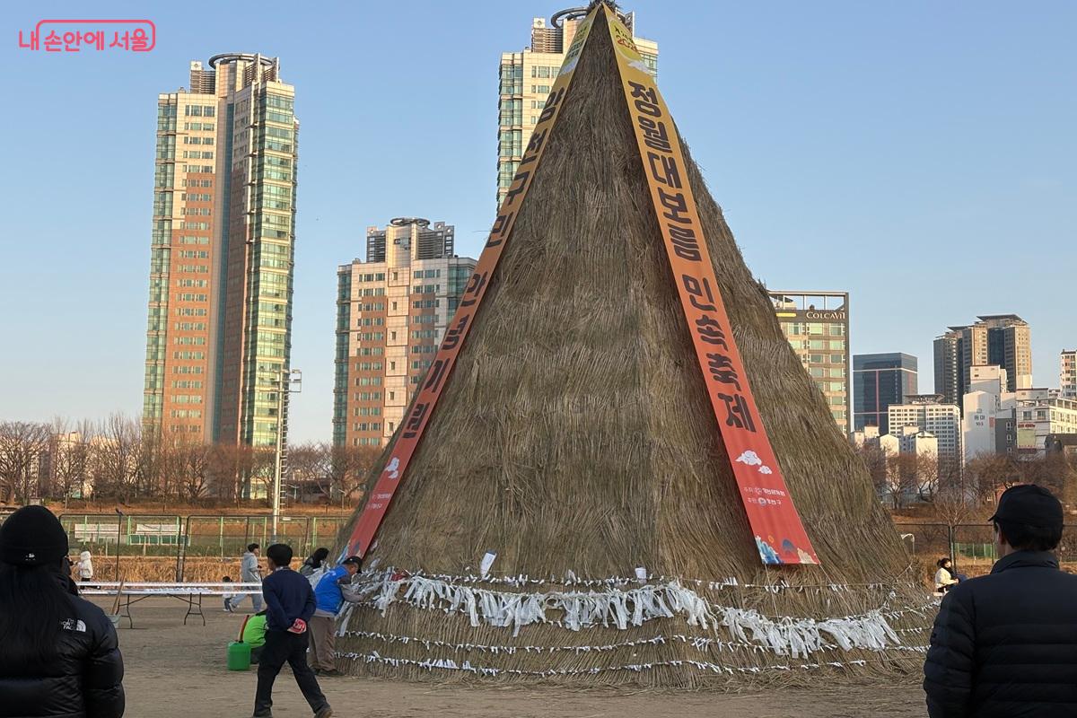 거대한 달집에 소원지를 묶고 있다. ⓒ조현영