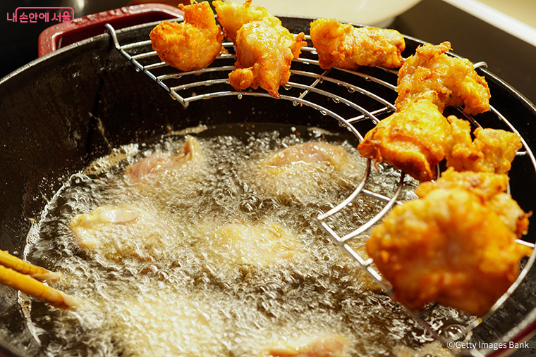 기름 속에 튀김 옷을 입힌 치킨을 담그면 지글거리는 모습을 볼 수 있다.