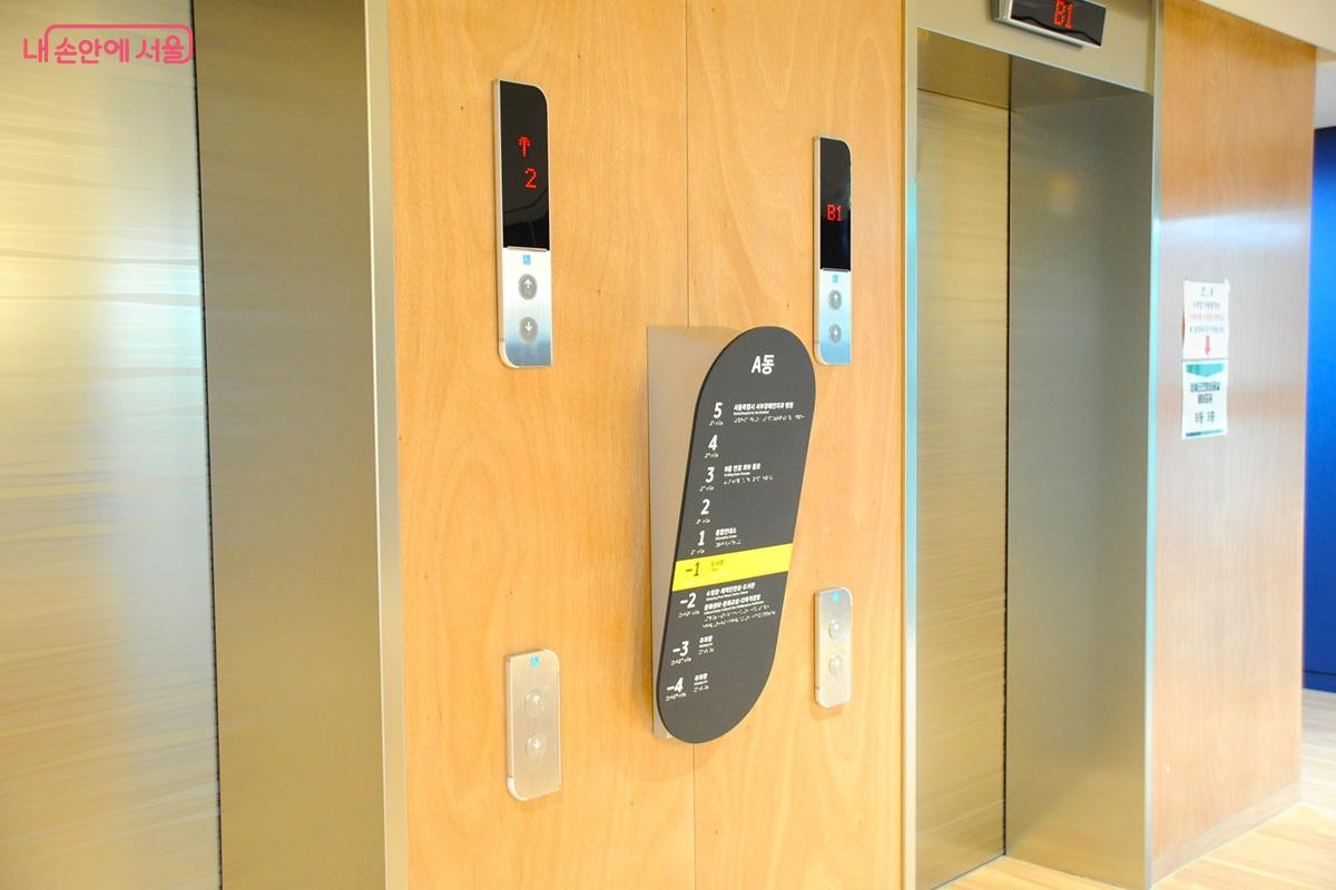 휠체어 이용자의 눈높이에 맞춘 기울기가 있는 층별 안내판과 상하 두 곳에 설치한 엘리베이터 버튼 &copy;조수봉