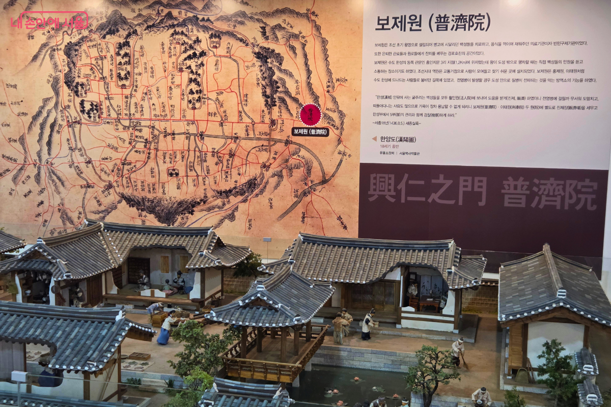 1층 실내 전시 공간이다. 벽면에는 '보제원(普濟院)'이라는 제목과 함께 한양의 옛 지도인 '한양도'가 크게 그려진 설명 패널이 부착되어 있다. 패널 아래 공간에는 옛 보제원 건물의 구조와 한복을 입은 사람들의 생활상을 정교하게 묘사한 전통 가옥 축소 모형(디오라마)이 넓게 펼쳐져 전시되어 있다.