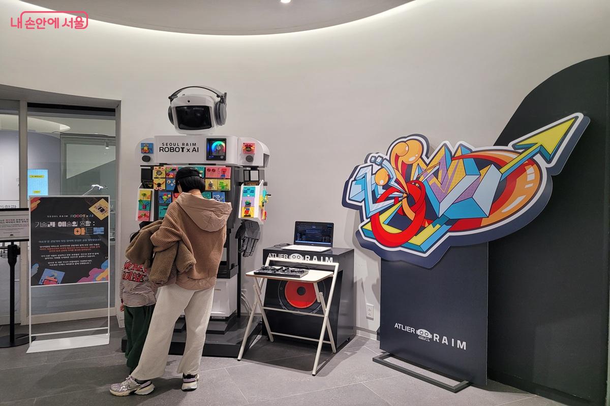 서울로봇인공지능과학관 체험 전시에서 부모와 아이가 함께 로봇 체험 프로그램에 참여하는 모습 &copy;조연