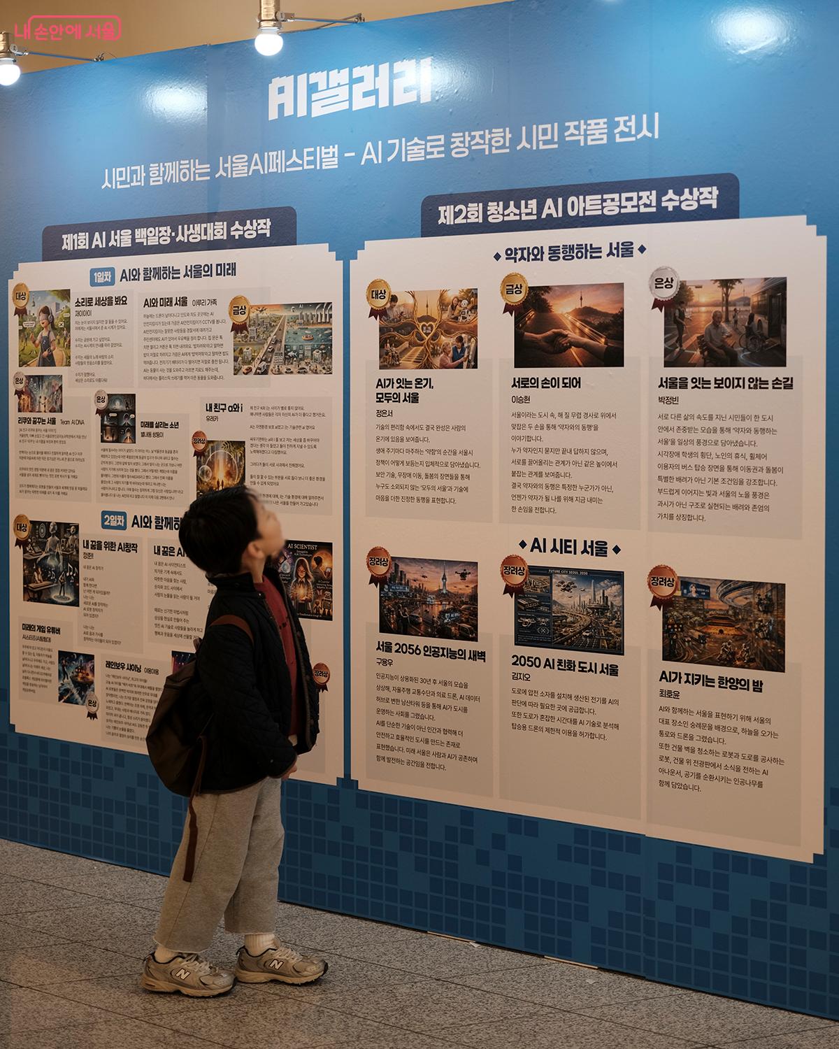 작년 AI 서울 백일장&middot;사생대회 수상작들을 전시하고 있는 패널. ⓒ김아름
