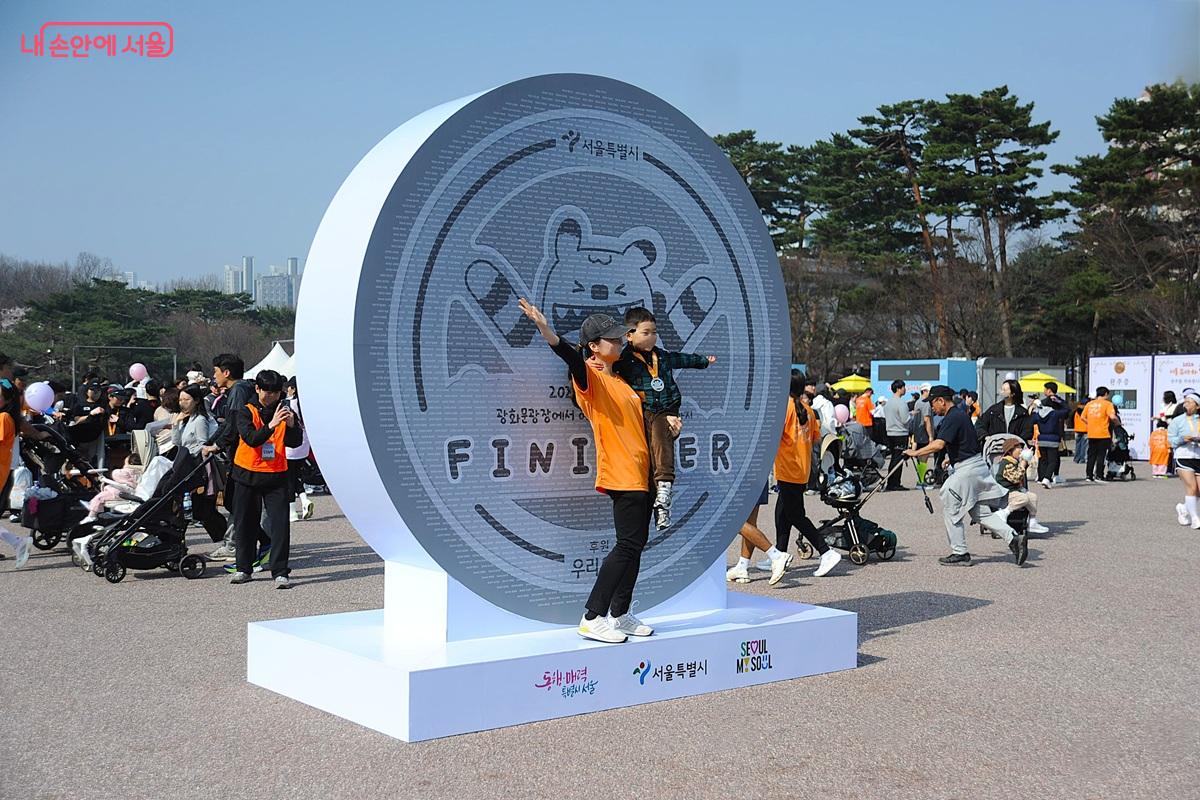 참가자들의 이름이 새겨진 &lsquo;네임월&rsquo; 앞에서 인증 사진을 찍는 가족 &copy;조수봉