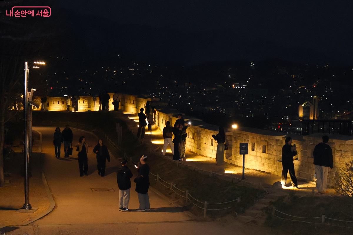 성곽의 조명을 가이드 삼아 밤 산책을 즐기며 여유를 만끽하는 관람객들의 모습 &copy;이봉덕