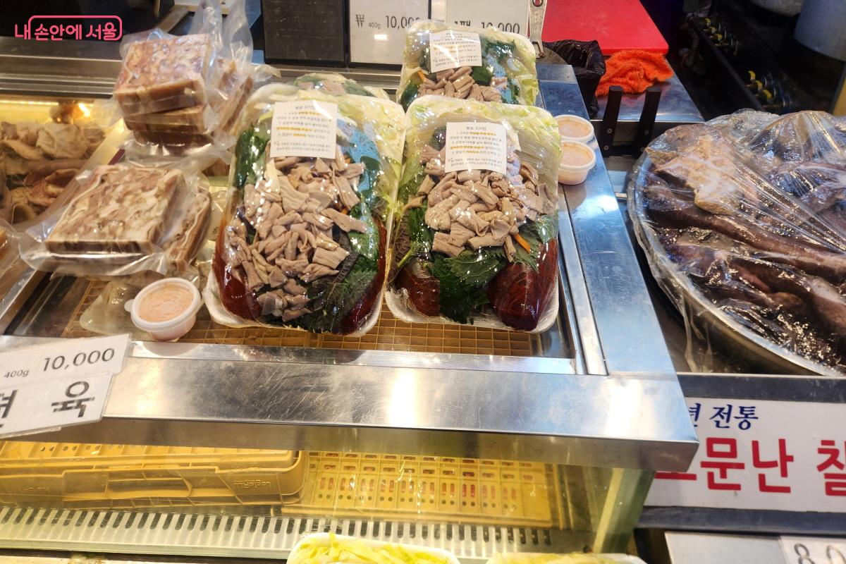 남구로시장 한 점포에서 편육과 순대를 판매하고 있다. 판매대에는 순대볶음 재료도 함께 진열돼 있으며, 가운데에는 볶는 방법과 조리 팁이 적힌 스티커가 붙어 있다.