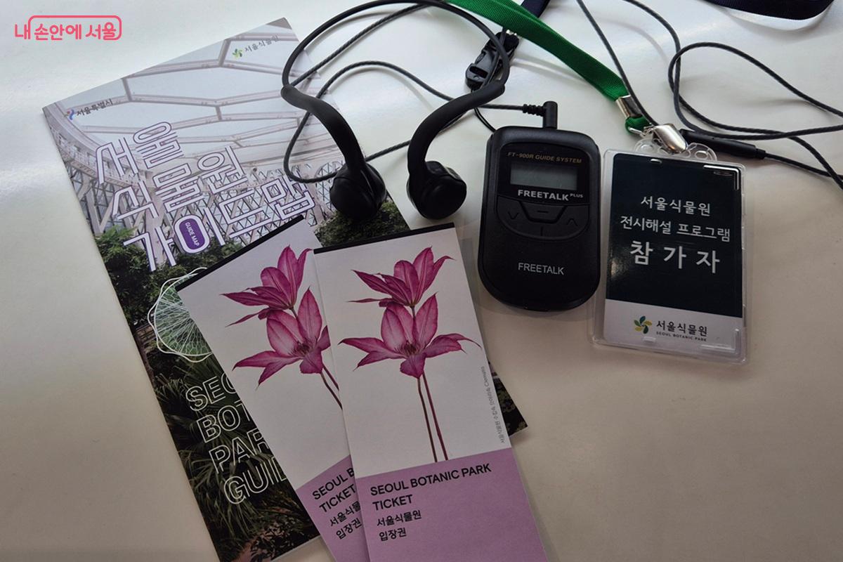 참가자 명찰과 이어폰, 송수신기, 서울식물원 입장권이 놓여있다. ⓒ마가은