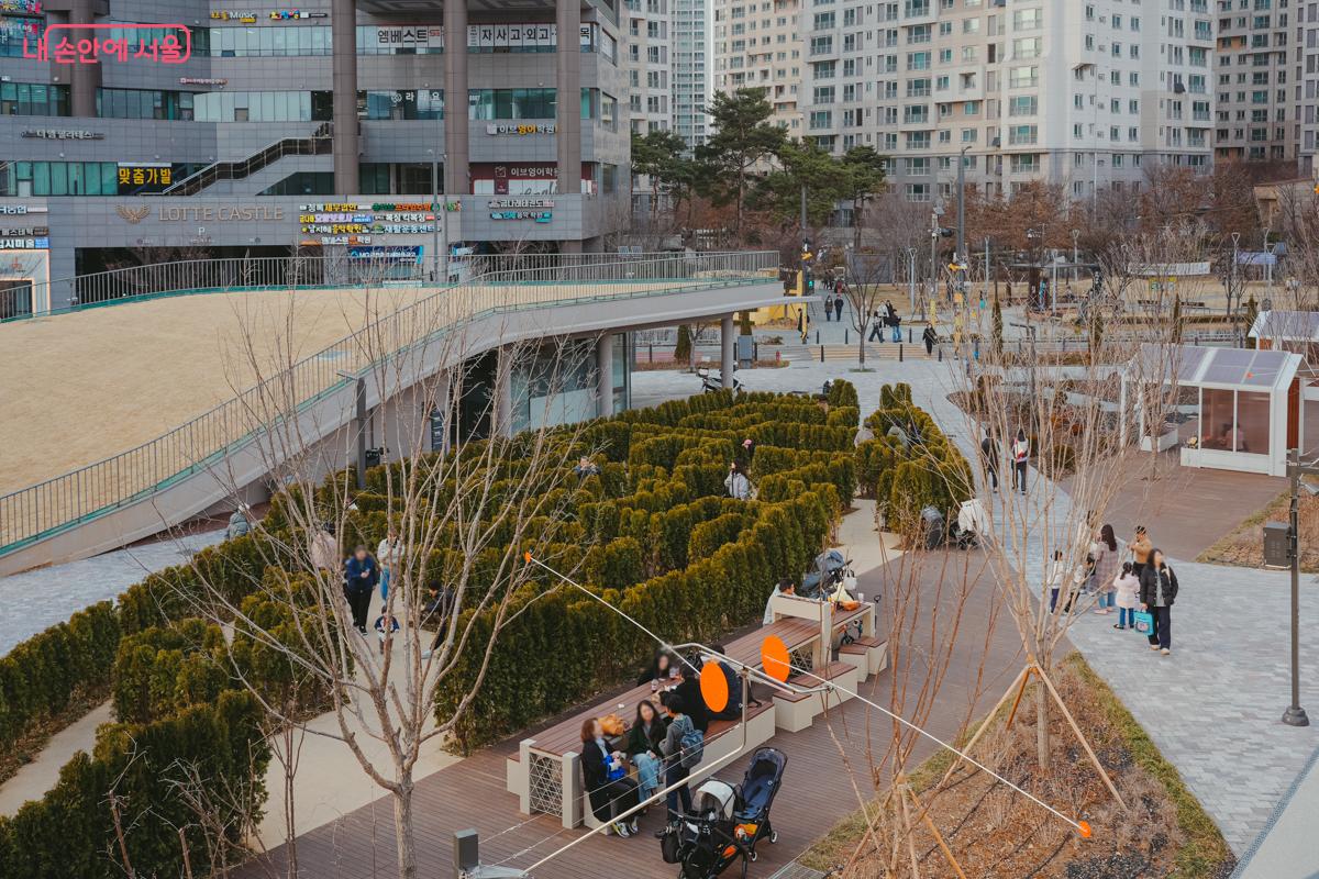 미술관과 인접한 공원의 미로정원을 위에서 내려다본 풍경. 빽빽하게 심어진 나무들 사이로 난 길을 따라 시민들이 걷고 있다.