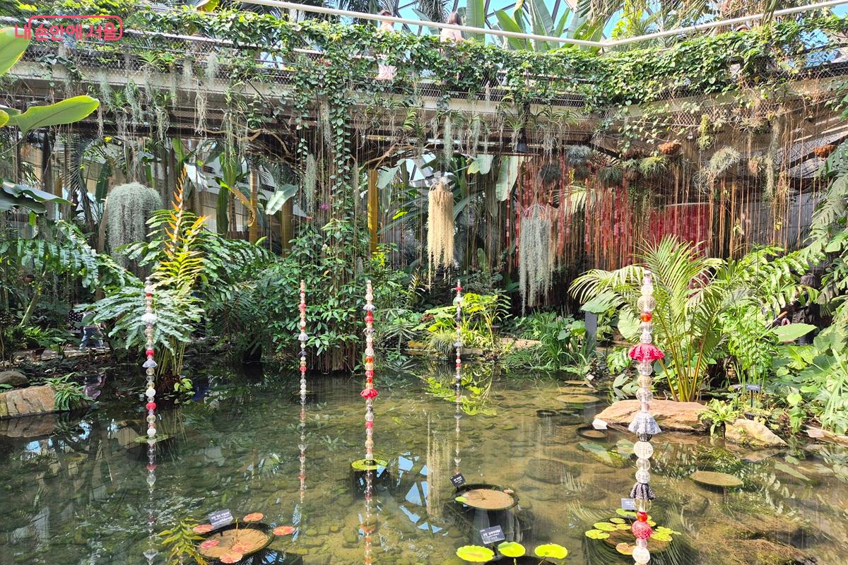 최성임 작가의 '줄기' 작품이 전시되고 있는 수공간의 모습이다. 반짝이는 재질의 전시작품으로 빛을 받아 수공간에 반짝임을 더해준다. ⓒ마가은