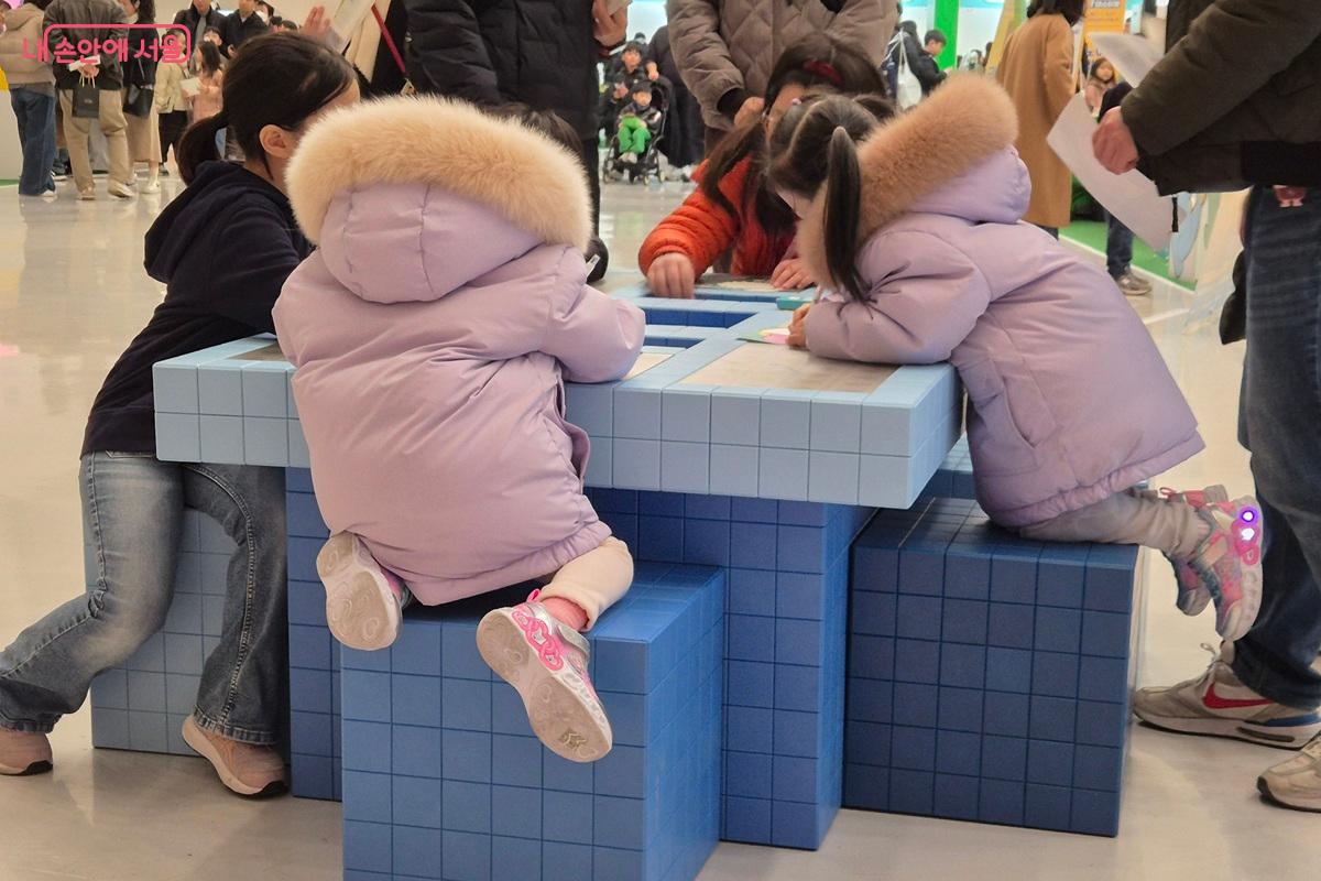 아이들이 나란히 둘러앉아 AI 바다에서 헤엄칠 나만의 물고기를 정성껏 색칠하고 있다. 옆 친구보다 더 특별한 물고기를 완성하겠다는 듯, 작은 손에 힘을 주고 집중하는 모습이 인상적이다. ⓒ마가은