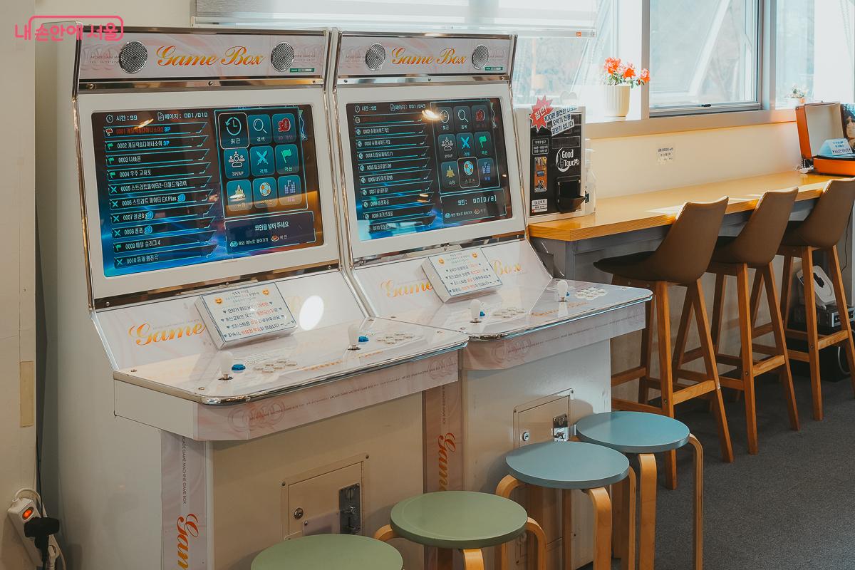 창가 쪽에 배치된 두 대의 하얀색 레트로 아케이드 오락기 &copy;김성무