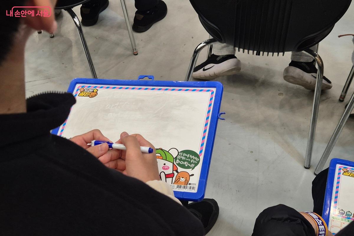 AI 골든벨에 참여한 긴장된 표정의 어린이가 펜을 두 손에 꼭 쥐고 문제를 기다리고 있다. ⓒ마가은 