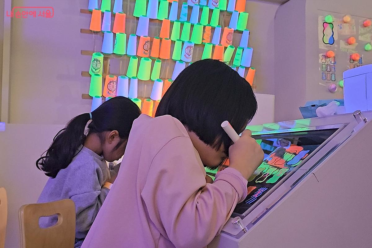 형광색 펜으로 플라스틱  종이에 곰돌이를 그려보는 어린이들 &copy;오도연