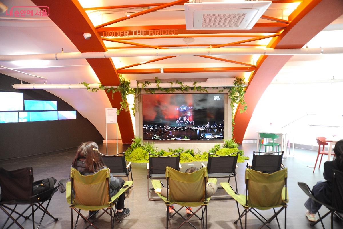 한강의 축제 장면을 화면으로 볼 수 있는 한강플플 3층의 &lsquo;언더 더 브릿지&rsquo; &copy;조수봉