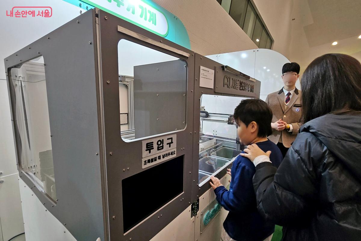 분리수거기계를 쳐다보는 관람객들 ⓒ김윤경