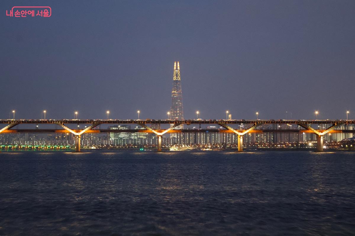 한강 다리 사이로 펼쳐진 도시의 불빛과 우뚝 솟은 빌딩의 조명이 함께하는 한강의 야경 ⓒ이봉덕
