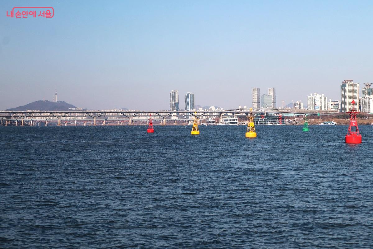 한강버스 항로의 알록달록한 부표 너머로 서울의 수려한 경관이 파노라마처럼 펼쳐진다. ⓒ이봉덕