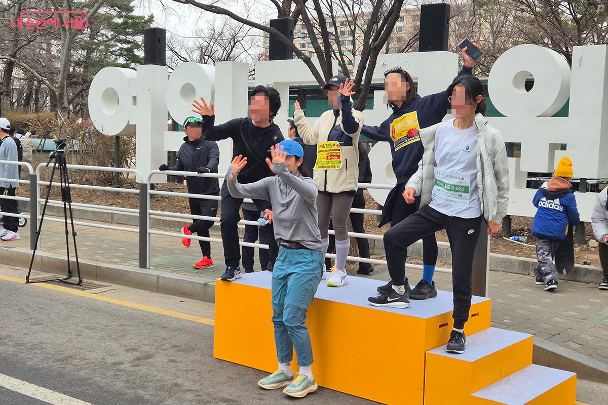 완주를 마치고 포토존에서 기념 사진을 찍는 런닝 동호회 회원들
