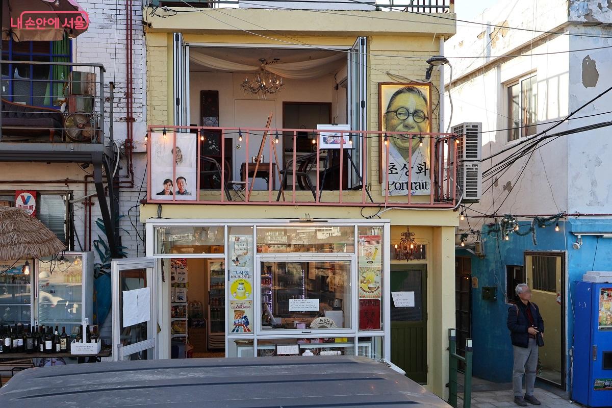 아기자기한 소품과 인물화가 걸린 노란 건물이 골목에 따스한 활기를 불어넣는다. &copy;이봉덕