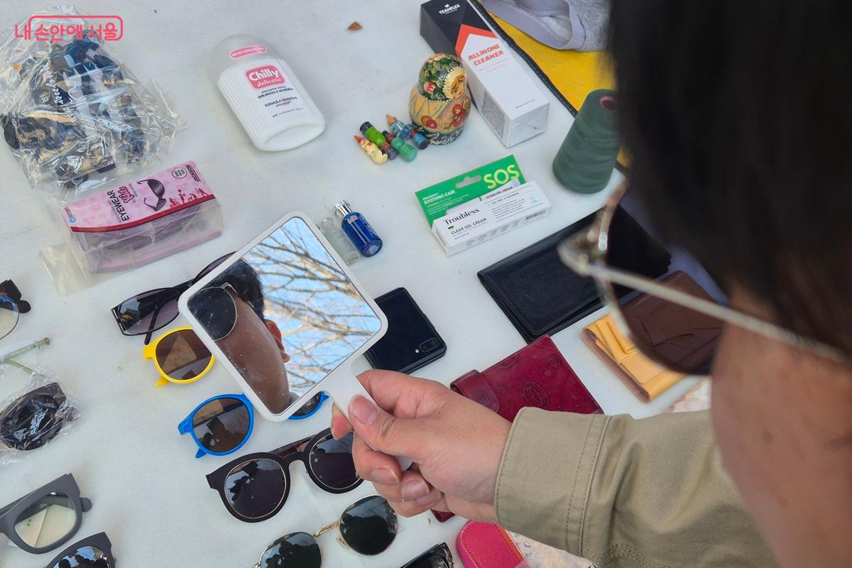 선글라스를 구경하던 시민이 마음에 드는 선글라스를 직접 착용하고 거울을 보며 구매를 고민 중이다. ©마가은