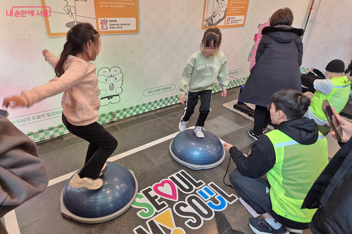 둥근 짐볼 위에 올라가 균형성을 측정하는 참가자들 ©백승훈